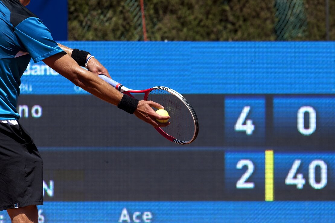 Spieler schlägt einen Tennisball